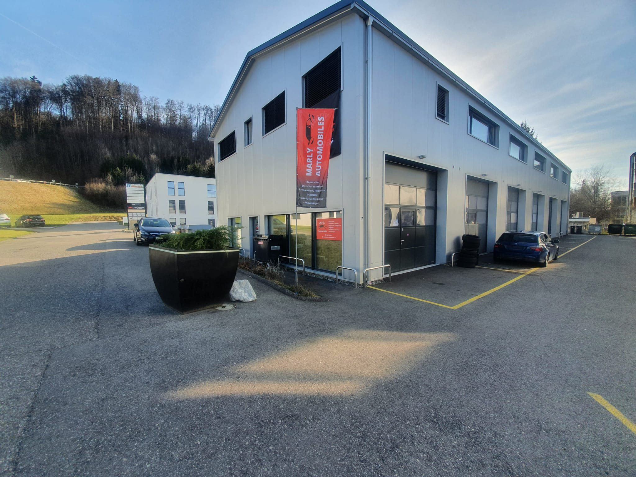 Le bâtiment de Marly Automobiles, Route de Chésalles 17 à Marly, avec sa bannière rouge